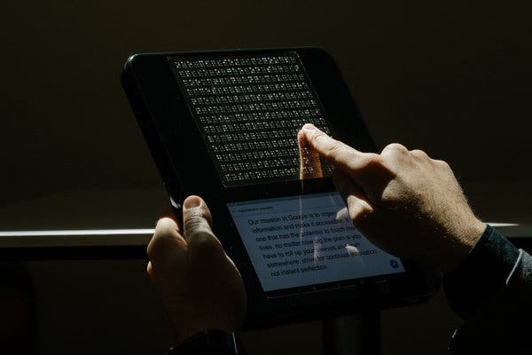 A user reading an ebook on a braille reader.